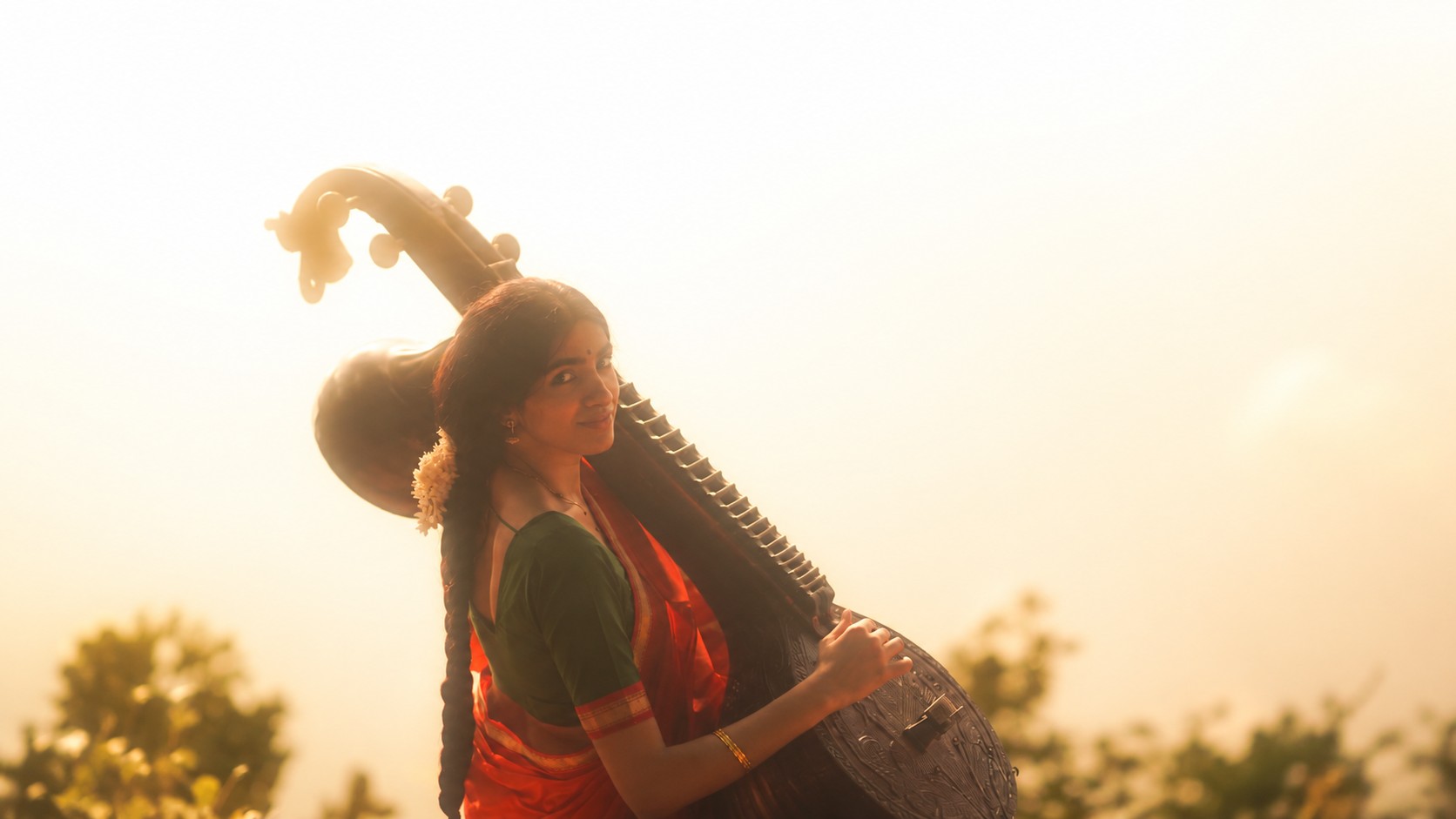 Classical musician playing a veena in warm golden hour light